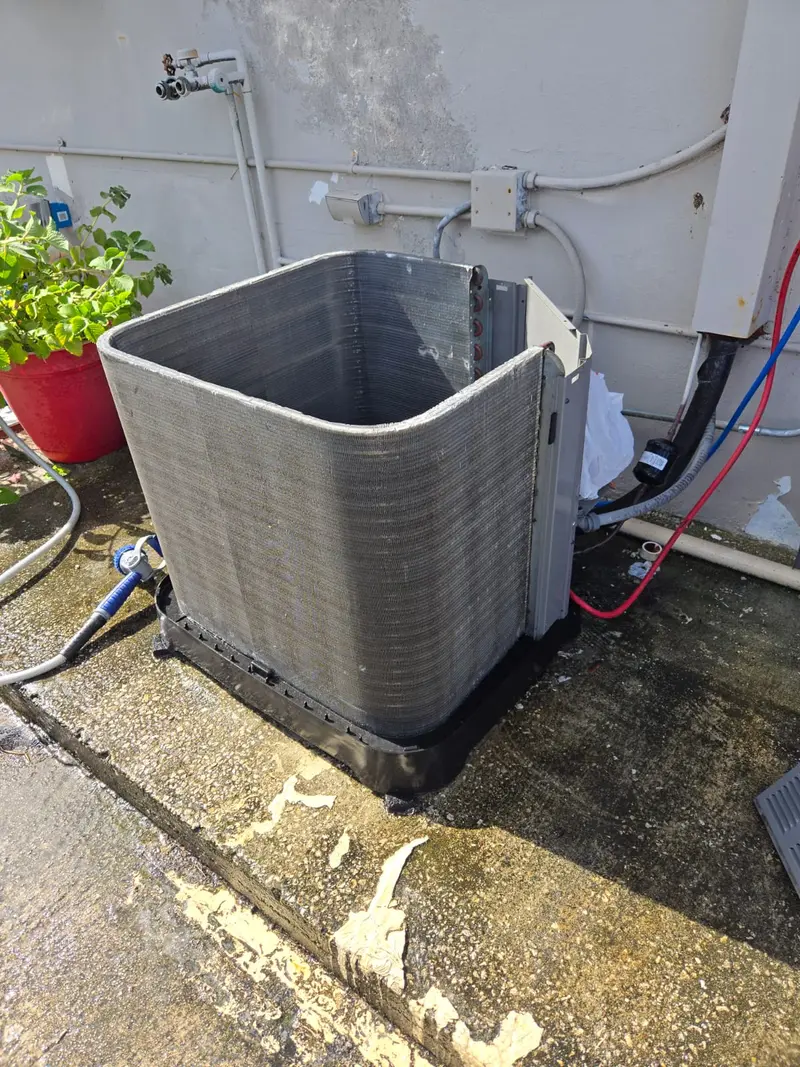 Outdoor AC condenser unit with the coil exposed during maintenance