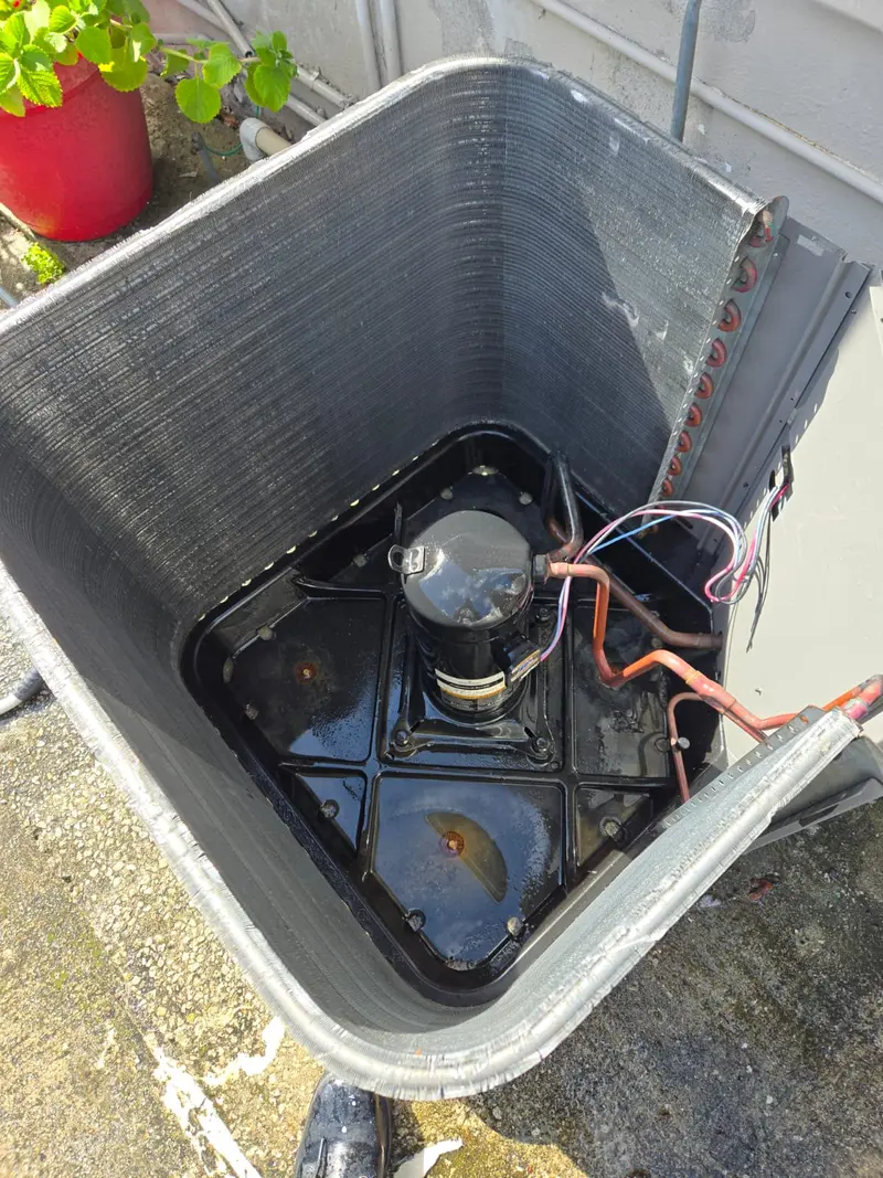 Inside of a condenser unit showing the compressor after coil cleaning